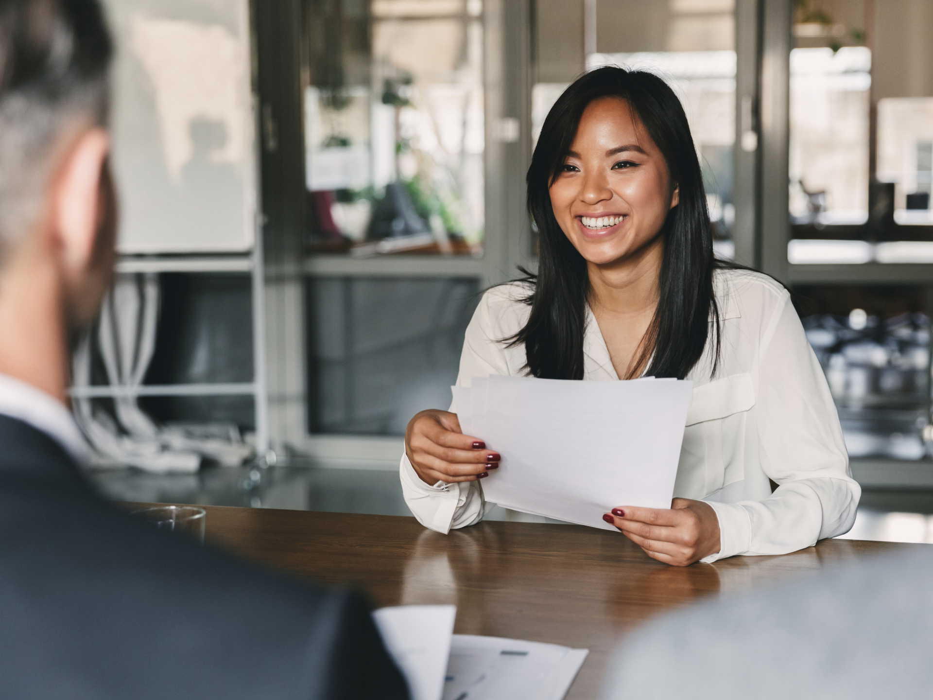 Applicant holding a resume and smiling at a job interview